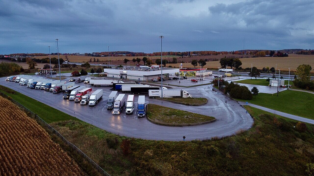 Caminhões estacionados em um posto de parada à beira da rodovia